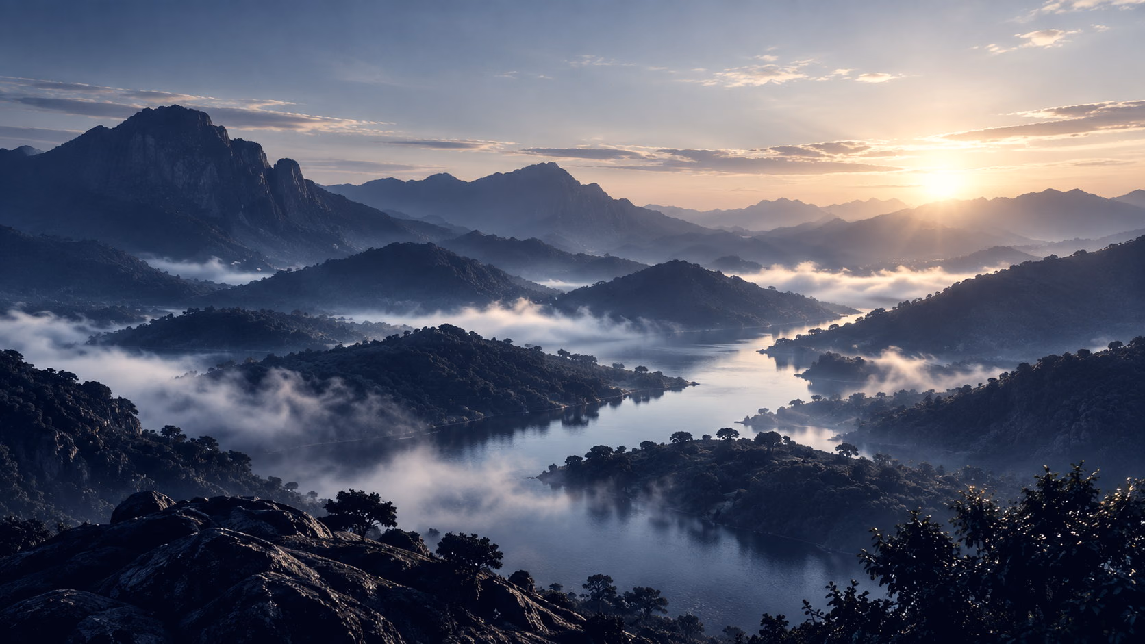 Mist lifting from a lake between forested hills at sunrise